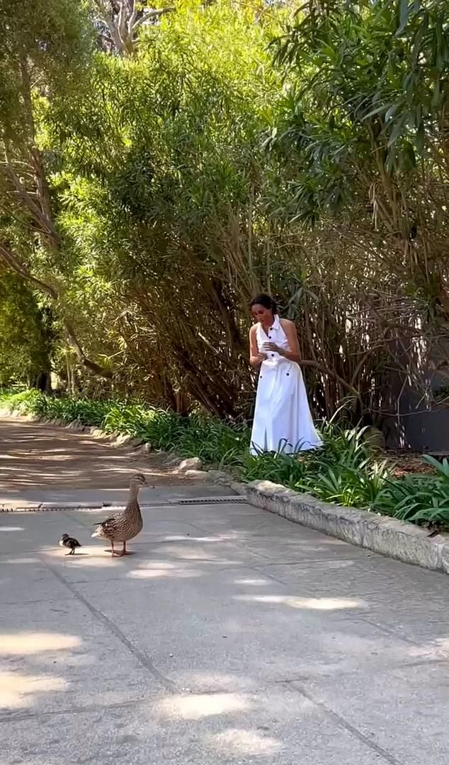 В этот весенний день Меган была в белом платье-миди без рукавов.