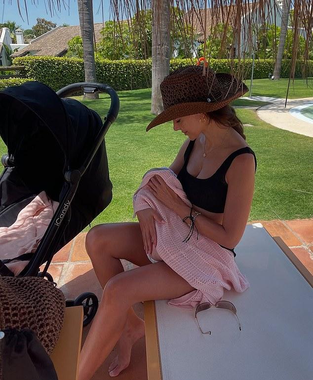 Michelle Keeganstunned as she modelled a swimsuit on Tuesday three months after welcoming a baby daughter with her husband Mark Wright