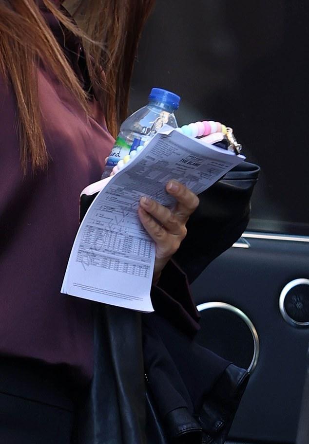 Из машины вышла 38-летняя актриса в рубашке и строгих брюках, засветив сценарий по пути в здание.