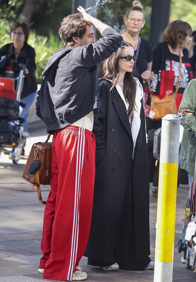 Он был с коричневой кожаной сумкой и сигаретой, пока они покидали терминал.