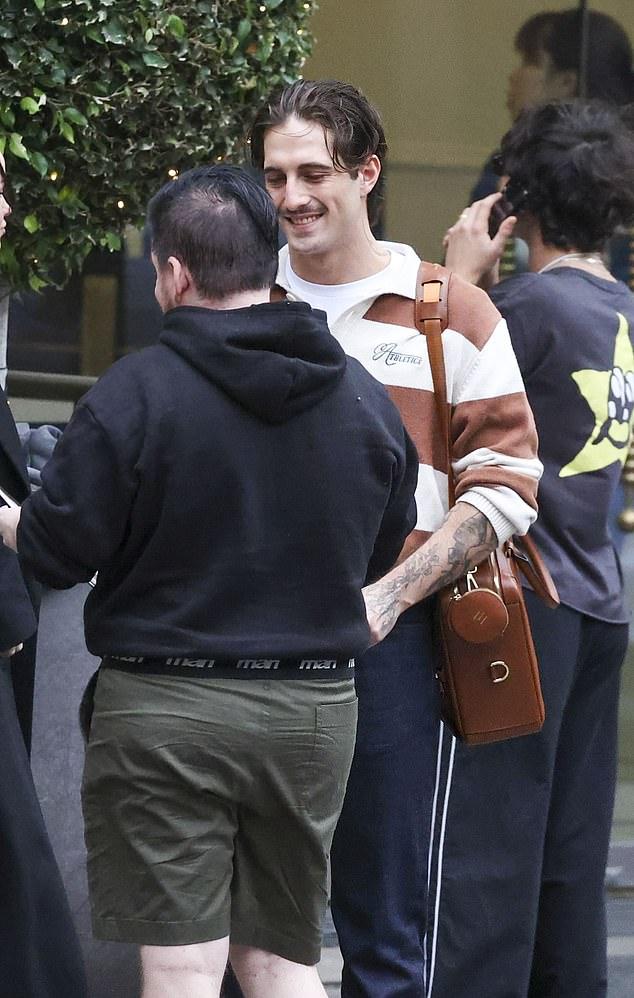 Дамиано выглядел очень стильно в полосатом коричнево-белом поло, темно-синих чиносах и $300 кроссовках Psylos1 тех же оттенков.