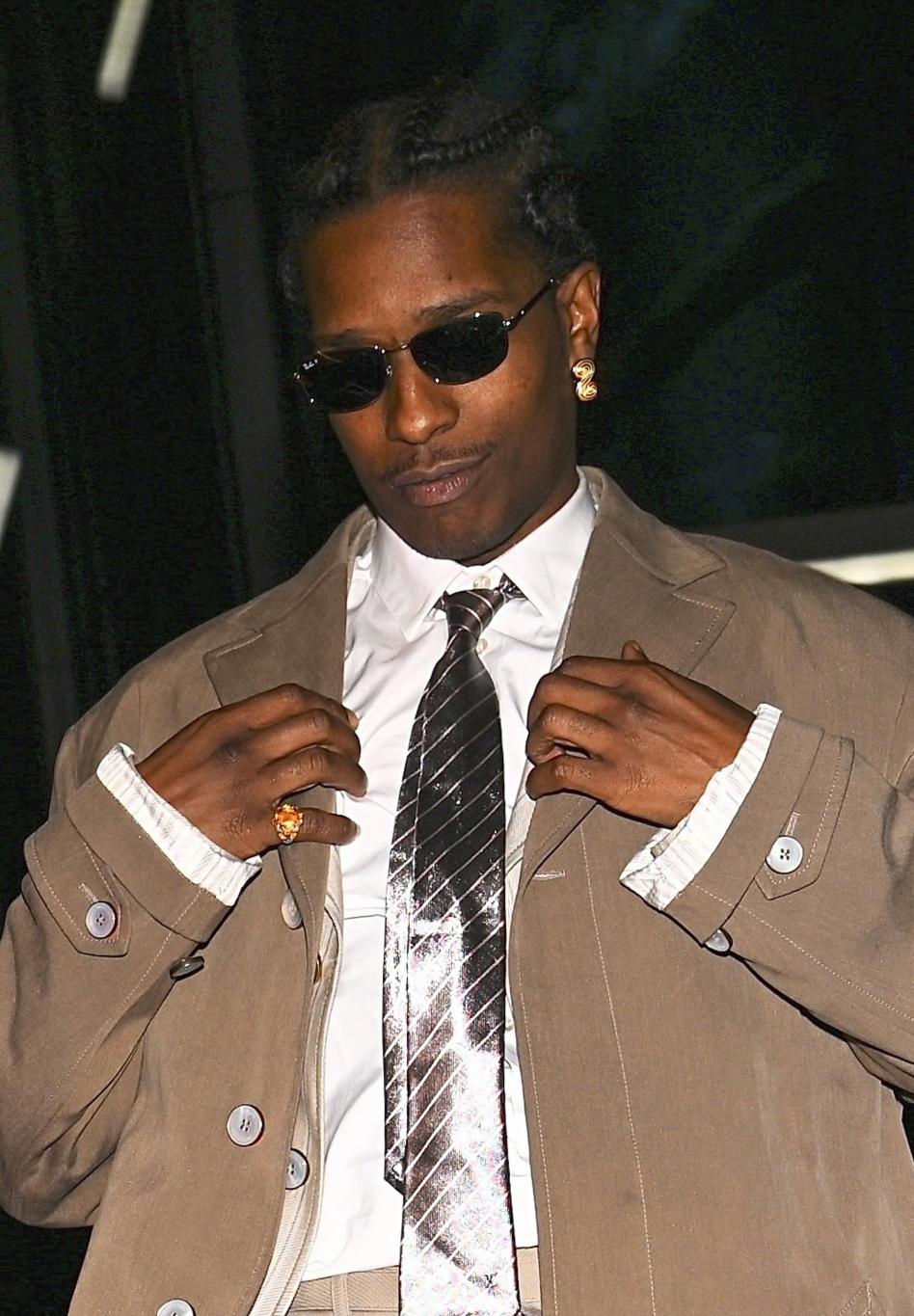 ASAP Rocky: стильный образ — бежевый тренч, белая рубашка, полосатый галстук, темные очки и золотые серьги.