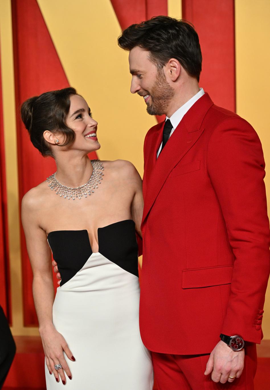 На оскаровской вечеринке Vanity Fair 2024 Альба Баптиста блистала в черно-белом платье, а Крис Эванс — в красном костюме.