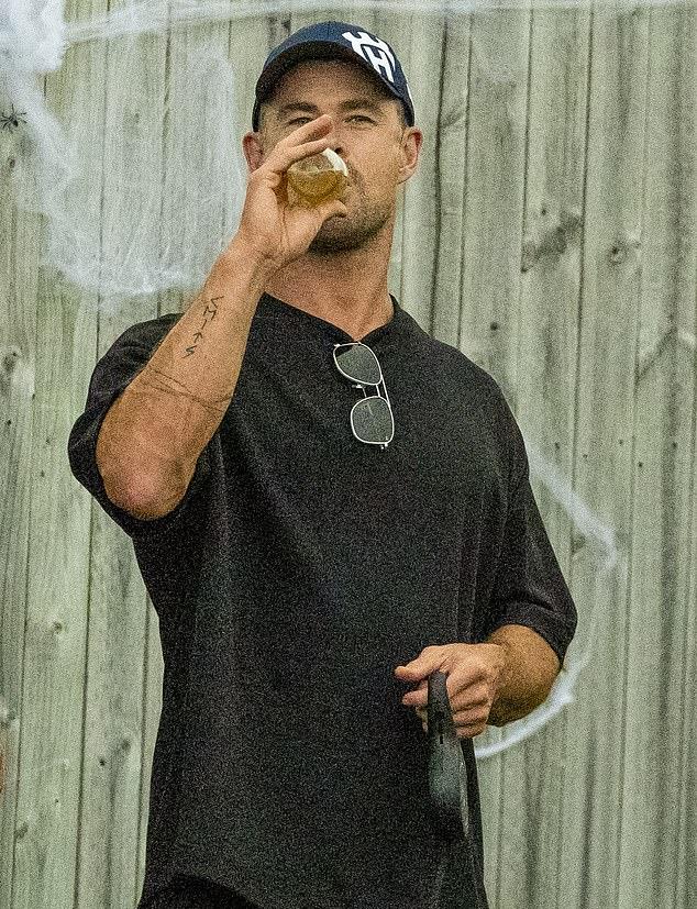 Лучисто улыбаясь, он наслаждался напитком на солнце, общаясь с друзьями.