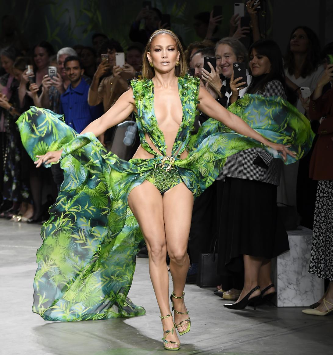 Дженнифер Лопес дефилирует по подиуму в эффектном зелёном струящемся платье Versace с глубоким декольте и дерзкими вырезами.