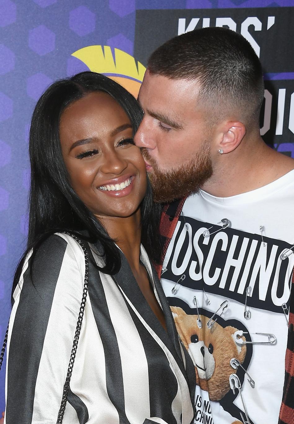 Игрок НФЛ Трэвис Келси целует телевизионную персону Кайлу Николь в щеку.