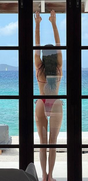 Она раскинула руки, позируя в красном бикини на одном снимке.