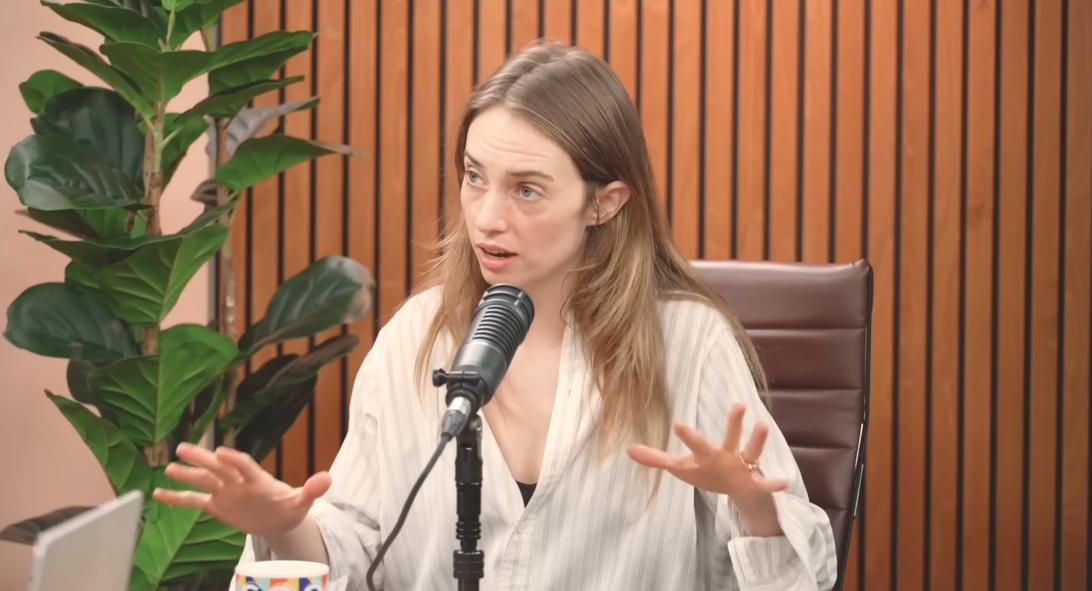 Майя Хоук выступает с микрофоном.