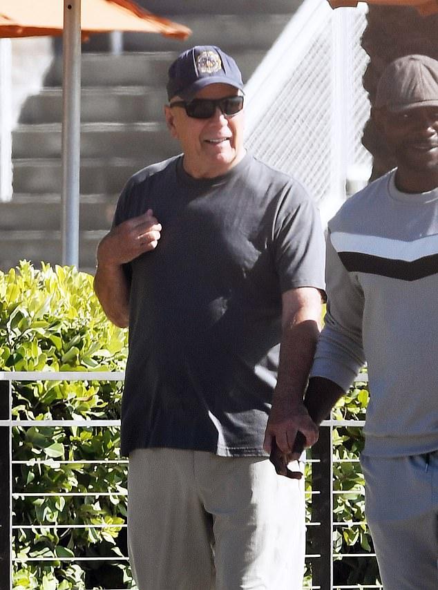 70-летний Брюс Уиллис, борющийся с лобно-височной деменцией, был сфотографирован на редкой публичной прогулке, держащим за руку опекуна.