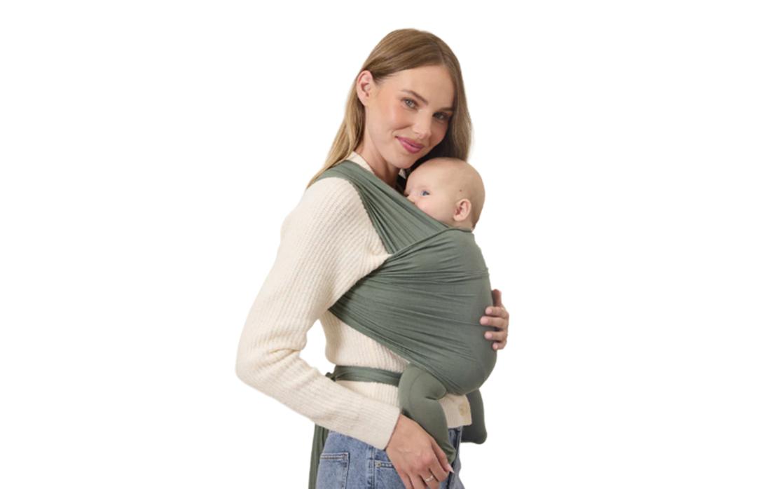 Модель несет малыша в слинге Solly Wrap.