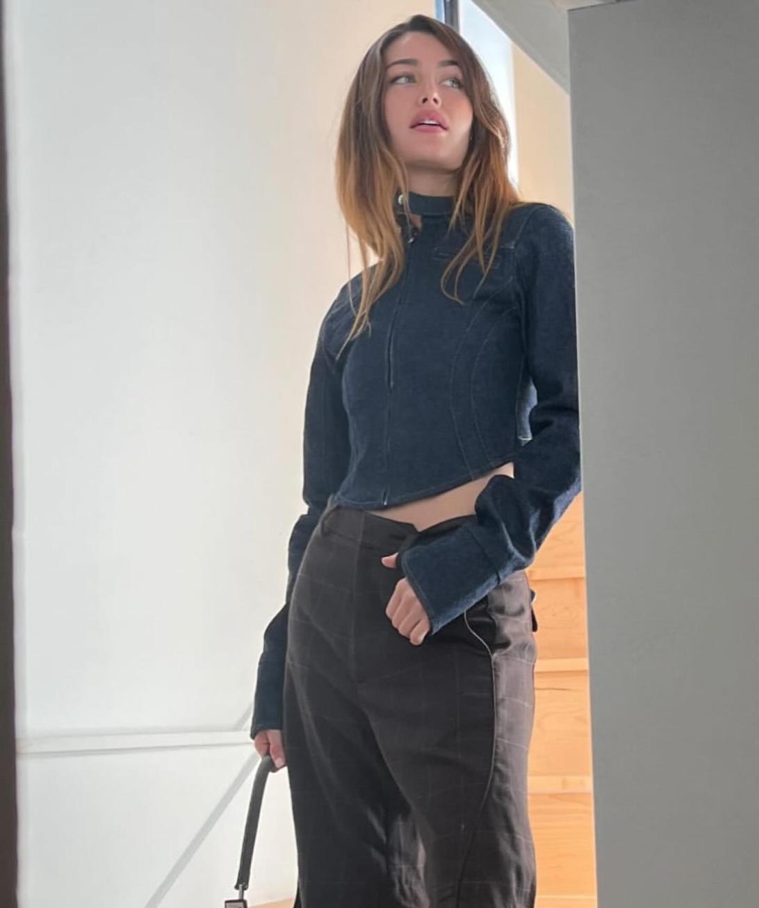 Рэйчел Линн Мэттьюз в темном джинсовом топе и клетчатых шортах.