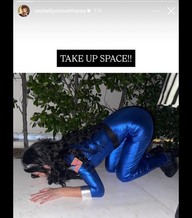 Рэйчел Линн Мэттьюз в синем скафандре, на четвереньках.