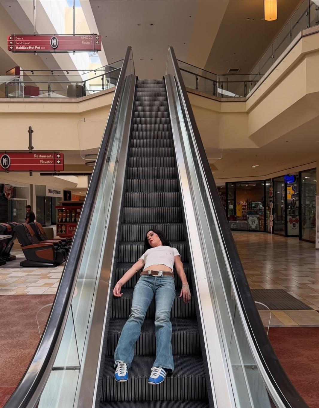 Кэти Перри на эскалаторе в торговом центре.