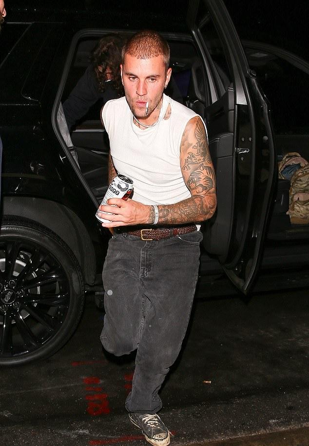 Тем временем Джастин предстал в более повседневном образе: белая майка, чёрные джинсы и коричневый ремень.