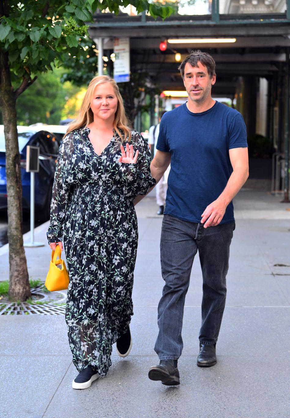 Эми Шумер и Крис Фишер прогуливаются вместе по тротуару.