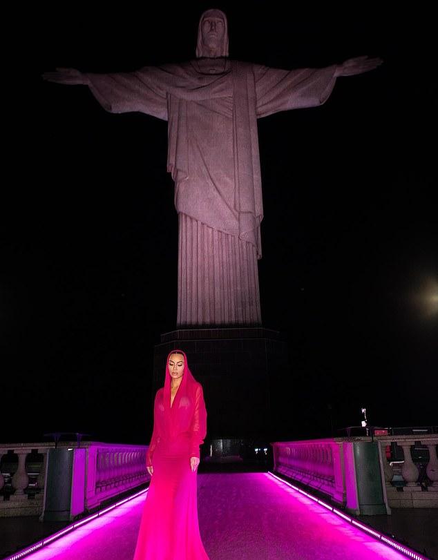 Звезда Кардашьян предстала в стильном вечернем образе, позируя на фоне высокой статуи в сумерках.