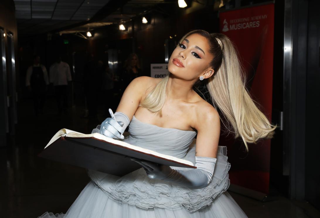 Ариана Гранде в изысканном светло-голубом платье и перчатках подписывает книгу.