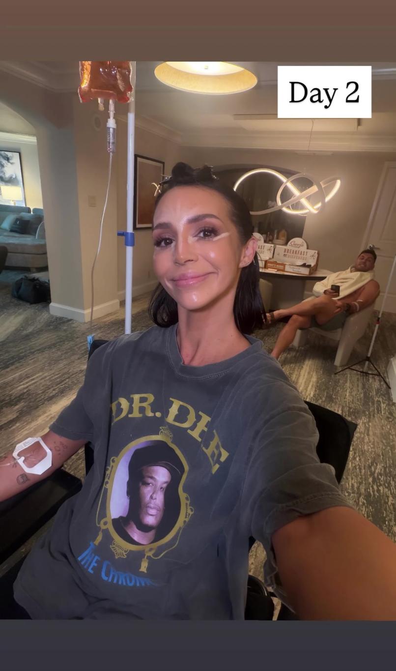 Пока улыбающаяся Шина Шэй под капельницей, Брок Дэвис нежится на заднем плане.