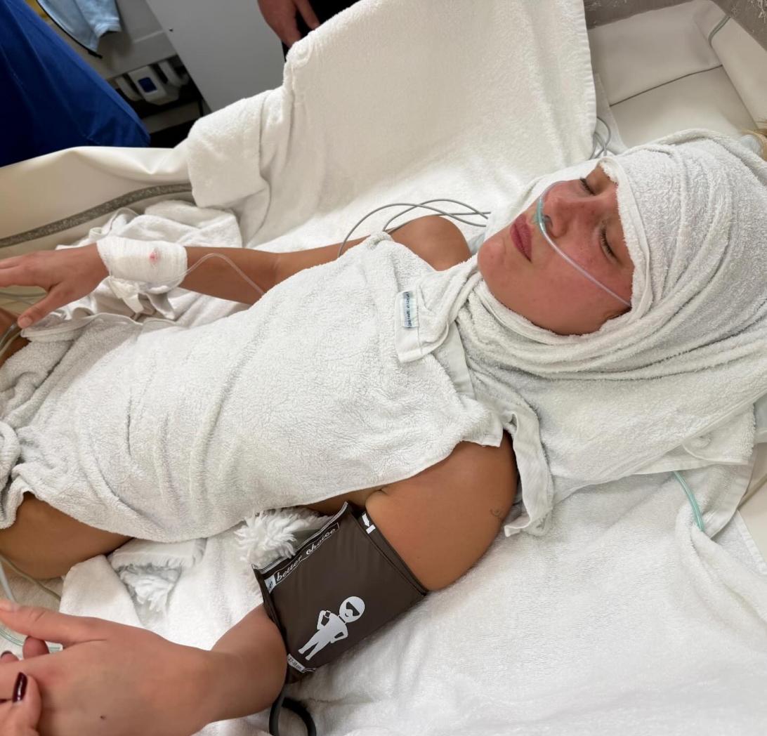 Белла Хадид на больничной койке под капельницей, с носовой канюлей и манжетой тонометра.