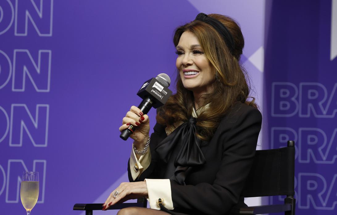 Лиза Вандерпамп выступает с микрофоном.