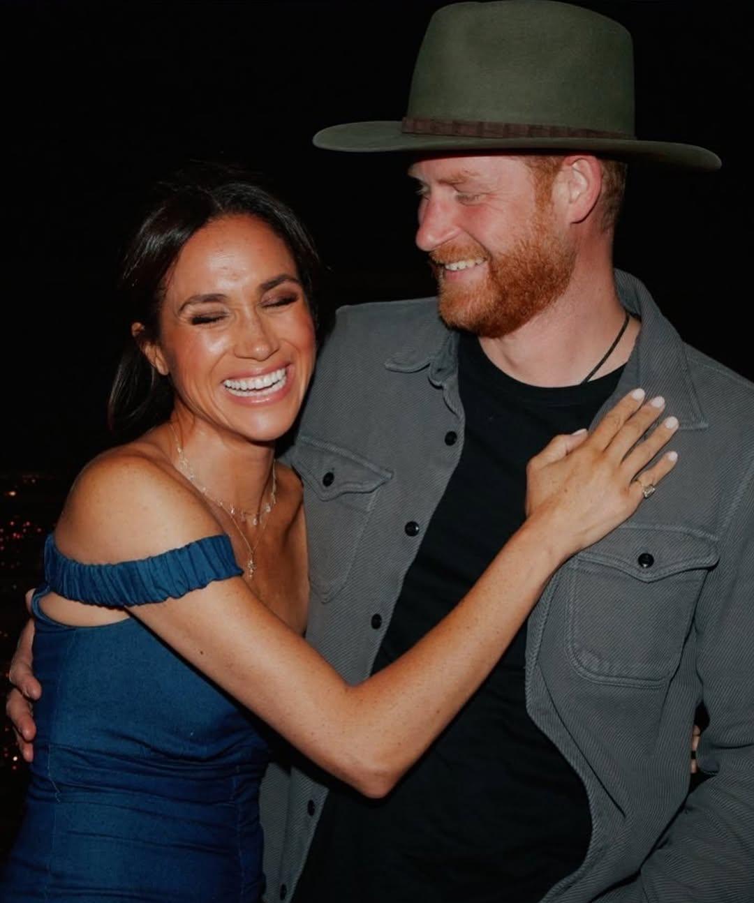 Меган Маркл и принц Гарри, сияющие улыбками, нежно обнимаются.