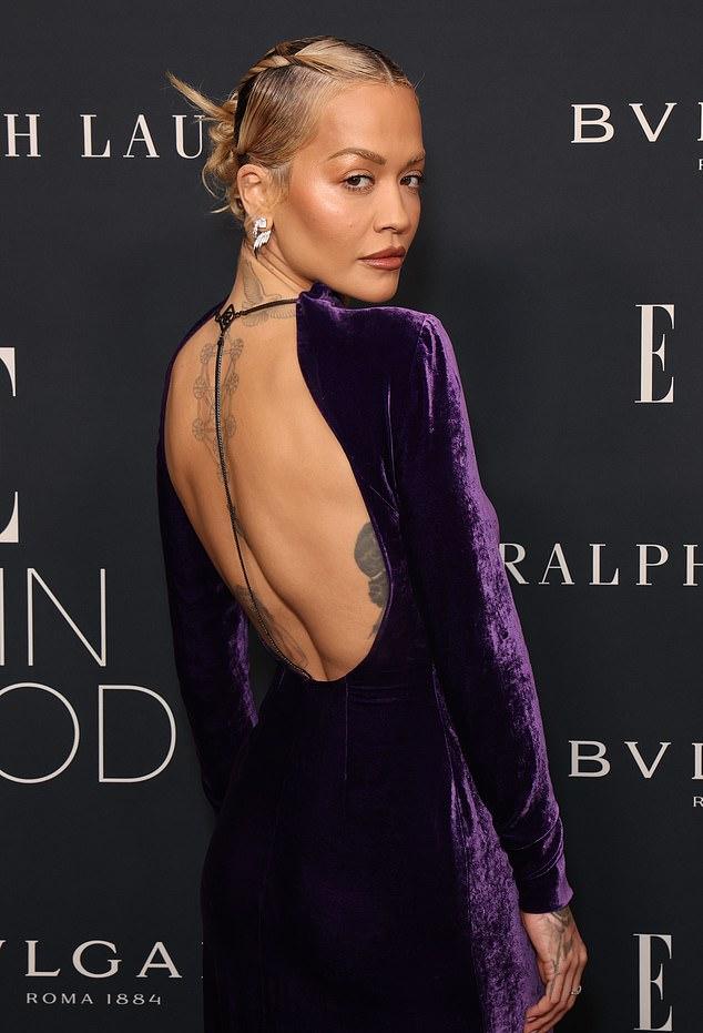 34-летняя певица надела облегающий наряд для вечеринки, отличавшийся открытой спиной и высоким воротником.