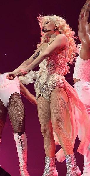 Наряд хитмейкера имел струящуюся деталь сбоку, а Гага придала росту серебряными ботильонами.