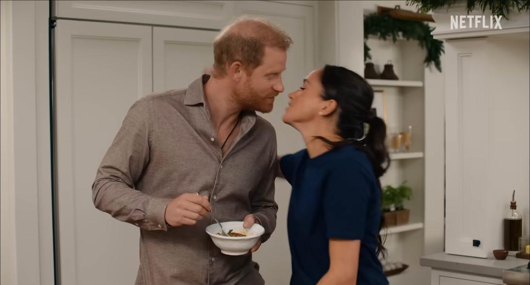 На кухне принц Гарри с миской, а Меган Маркл нежно склоняется для поцелуя.