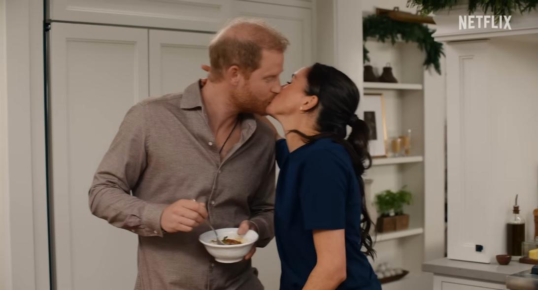 Меган Маркл нежно целует принца Гарри, держащего миску.