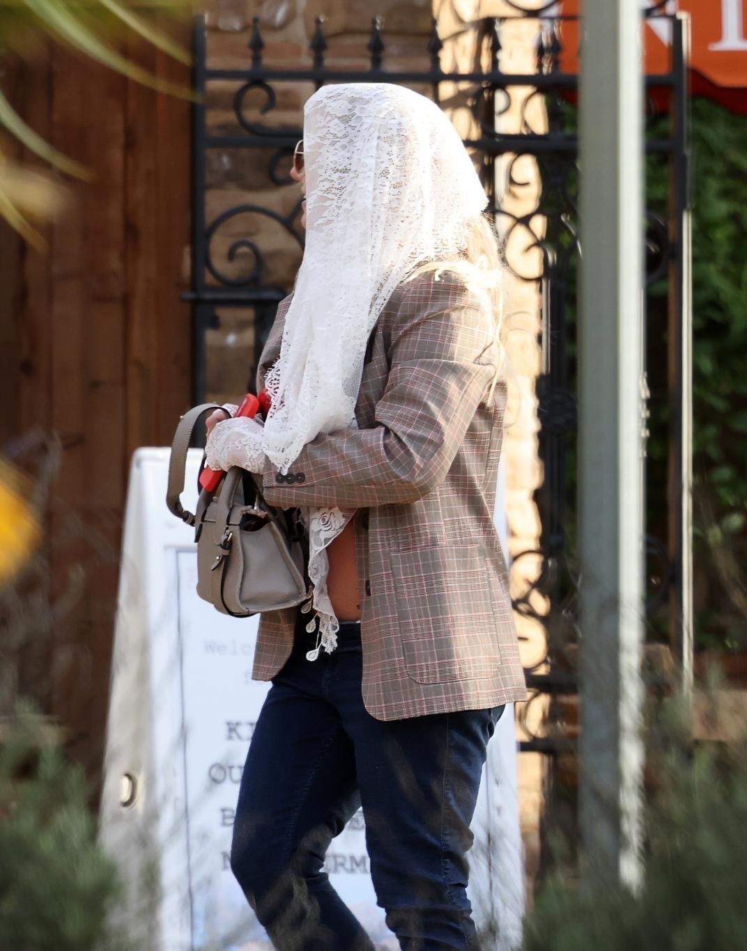 Бритни Спирс покидает спа и винодельню, скрыв голову белым кружевом.