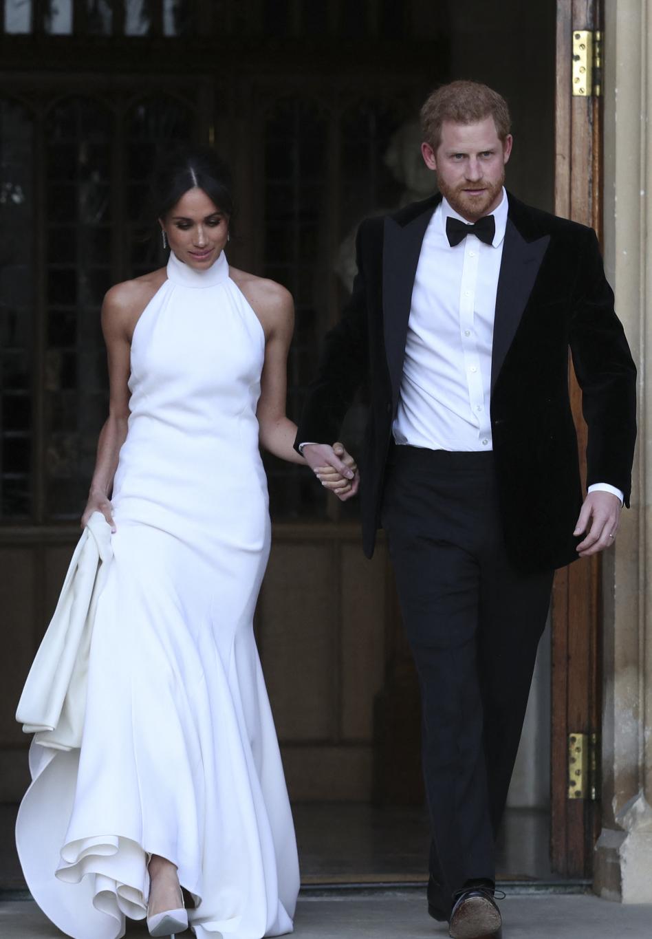 Молодожены принц Гарри и Меган Маркл, герцог и герцогиня Сассекские, держатся за руки, покидая Виндзорский замок.