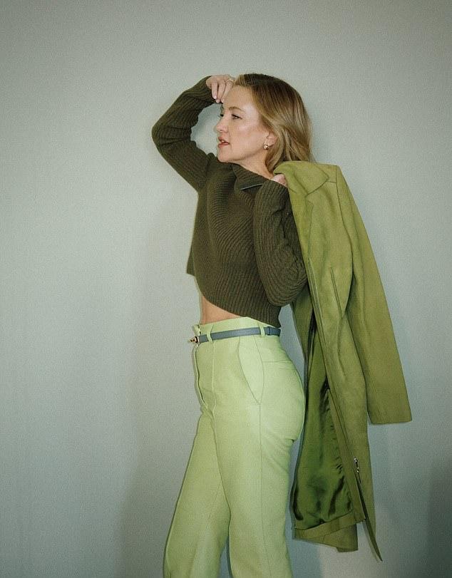Поверх темно-зеленого джемпера певица надела длинное пальто-платье на молнии и классические брюки.
