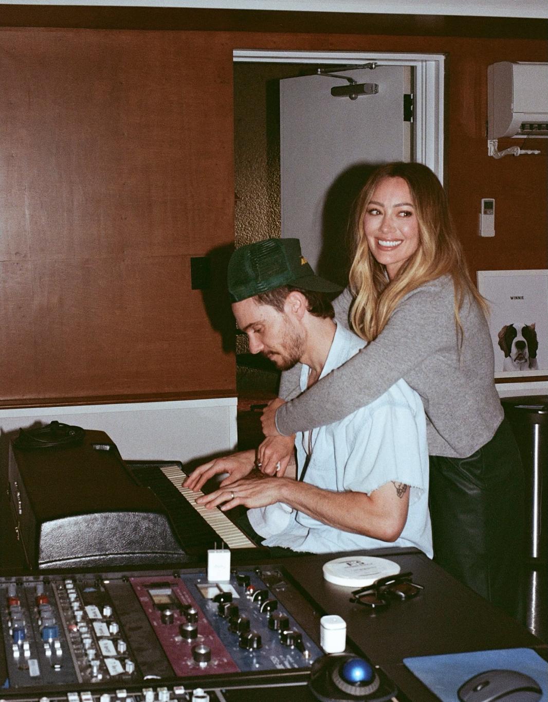 Хилари Дафф обнимает клавишника в студии звукозаписи.
