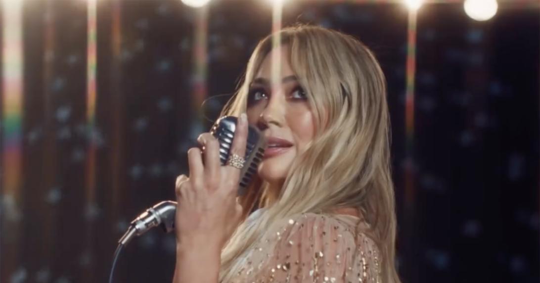 Хилари Дафф поет в микрофон.