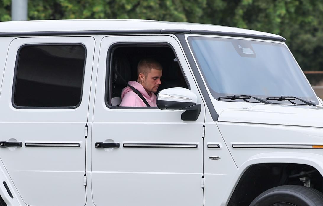 Джастин Бибер в розовом худи, сидящий на пассажирском сиденье электрического G-Wagen.