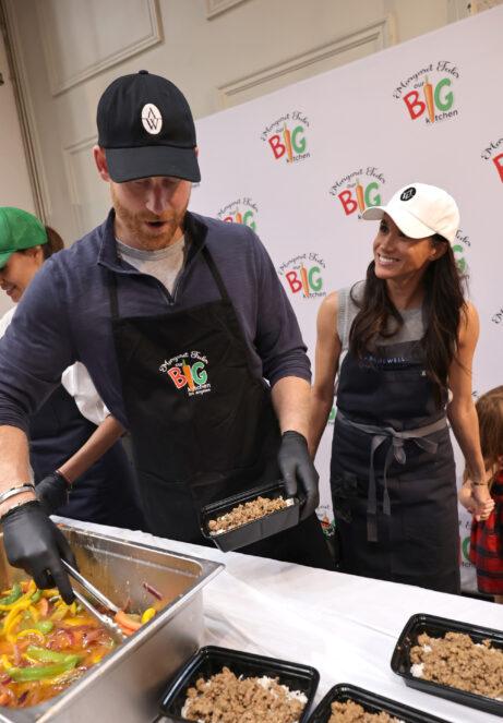 Принц Гарри раскладывает еду по контейнерам под улыбку Меган Маркл.