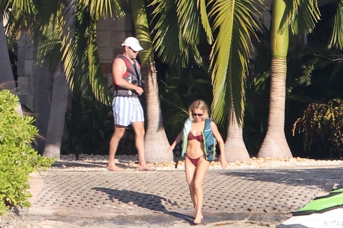 Сидни Суини в бордовом бикини и Скутер Браун в полосатых шортах, оба в спасательных жилетах, на Флорида-Кис.