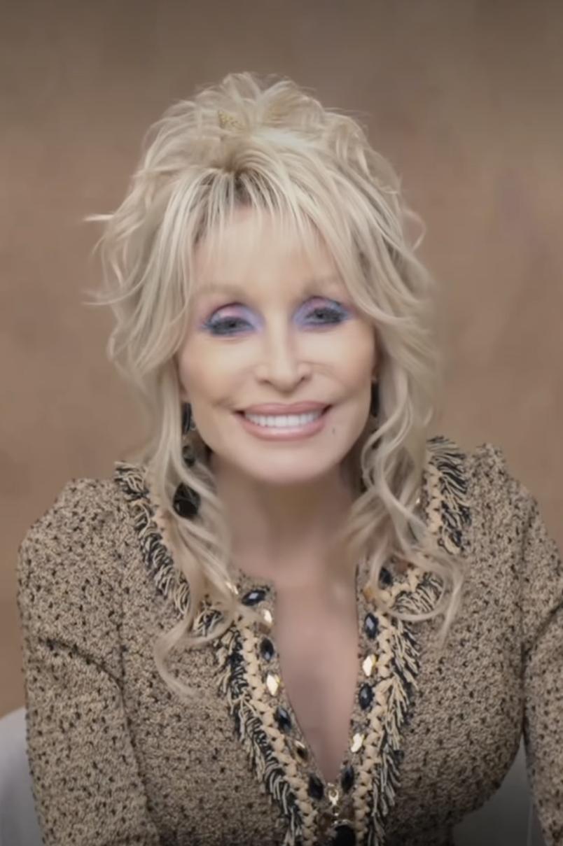 Улыбающаяся Долли Партон в фактурном блейзере с декоративной отделкой.