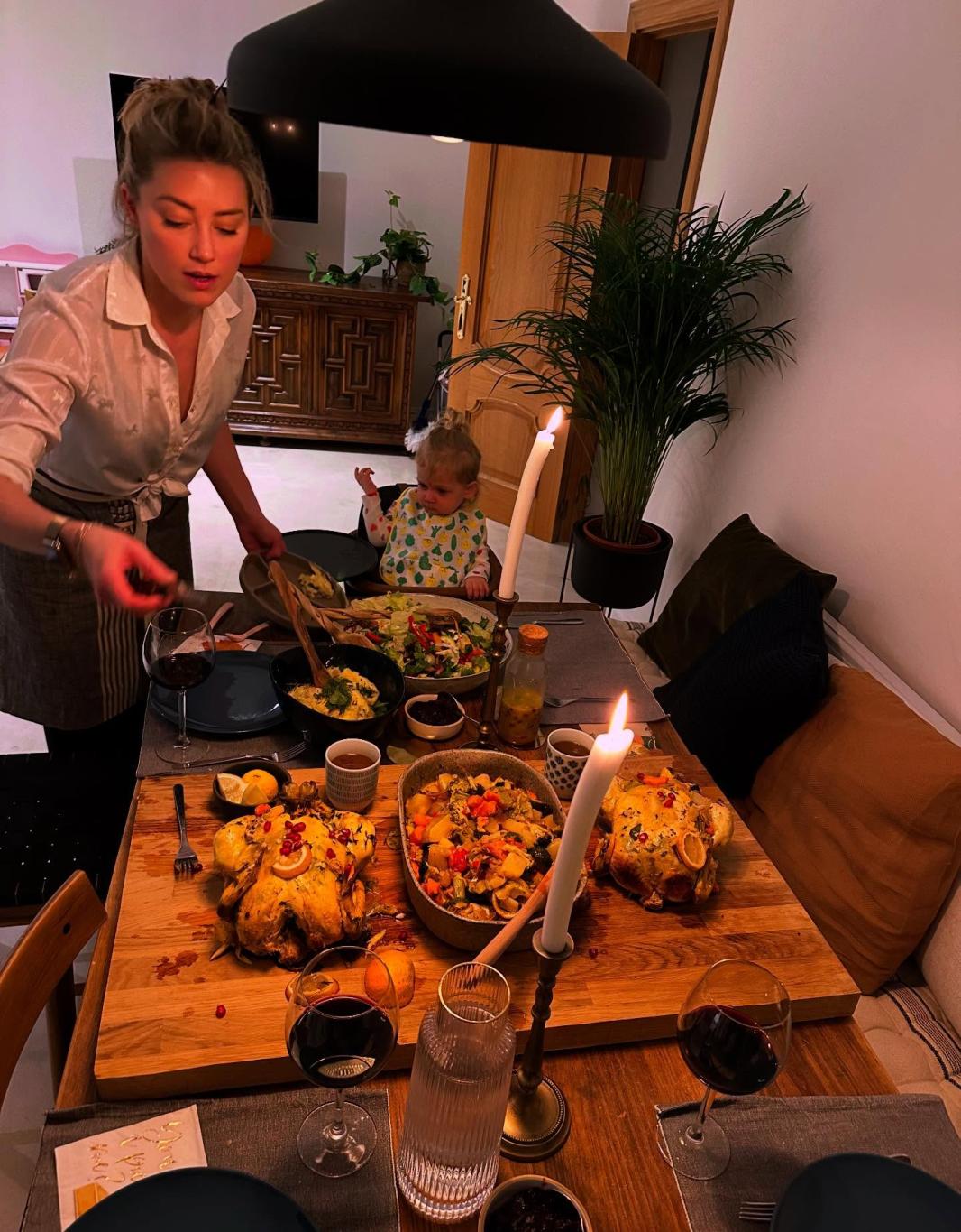 Эмбер Хёрд подаёт ужин на День благодарения, на заднем плане — малыш в детском стульчике.