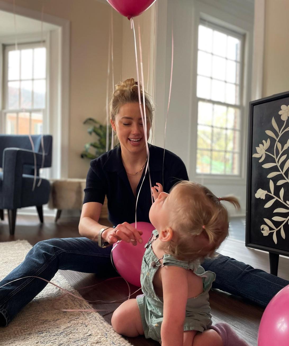 Эмбер Херд с дочкой радостно играют с розовыми воздушными шарами.
