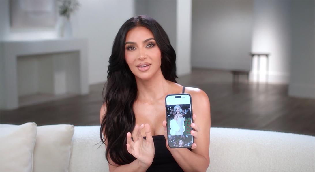Ким Кардашьян с телефоном, на экране которого — её фотографии.
