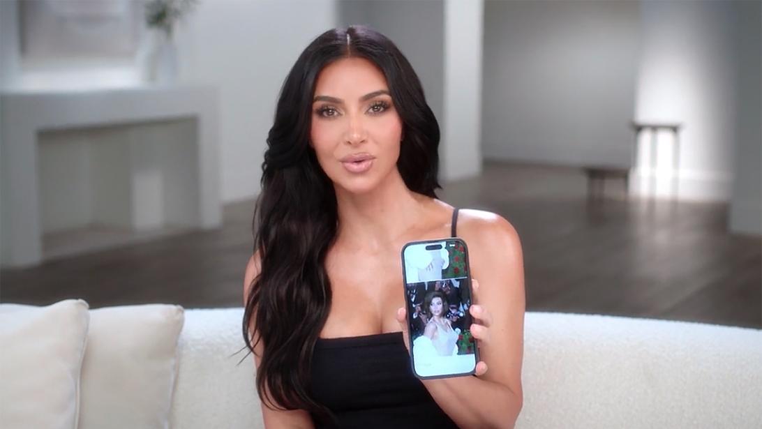 Ким Кардашьян держит телефон с фото Кайли Дженнер на экране.