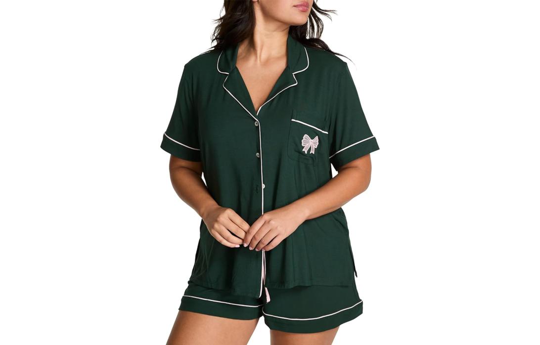 На модели темно-зеленая короткая пижама с белым кантом и бантом на кармане.