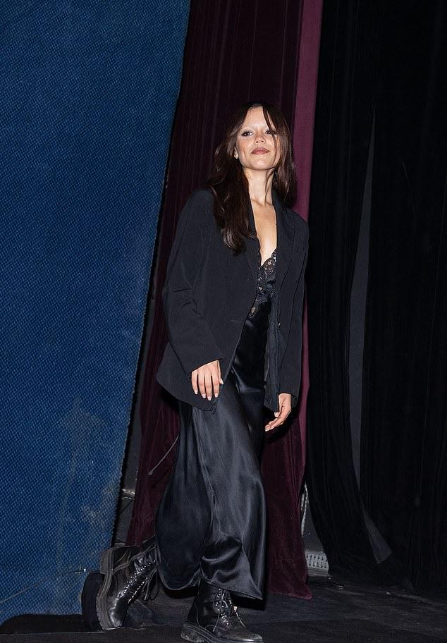 Она дополнила куртку широкими чёрными атласными брюками и чёрными шнурованными берцами.