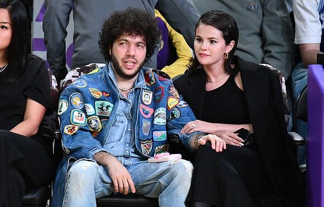 Селена предстала в стильном total black образе: черное пальто, облегающий топ, брюки в тон и высокие кожаные сапоги.