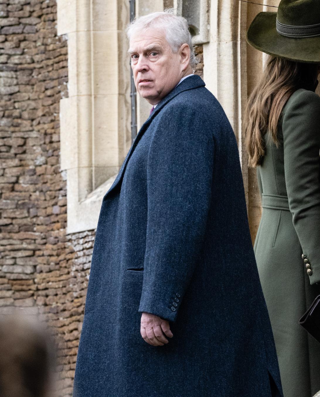 Принц Эндрю в синем пальто, оглядываясь через плечо на камеру, в церкви Сандрингем.