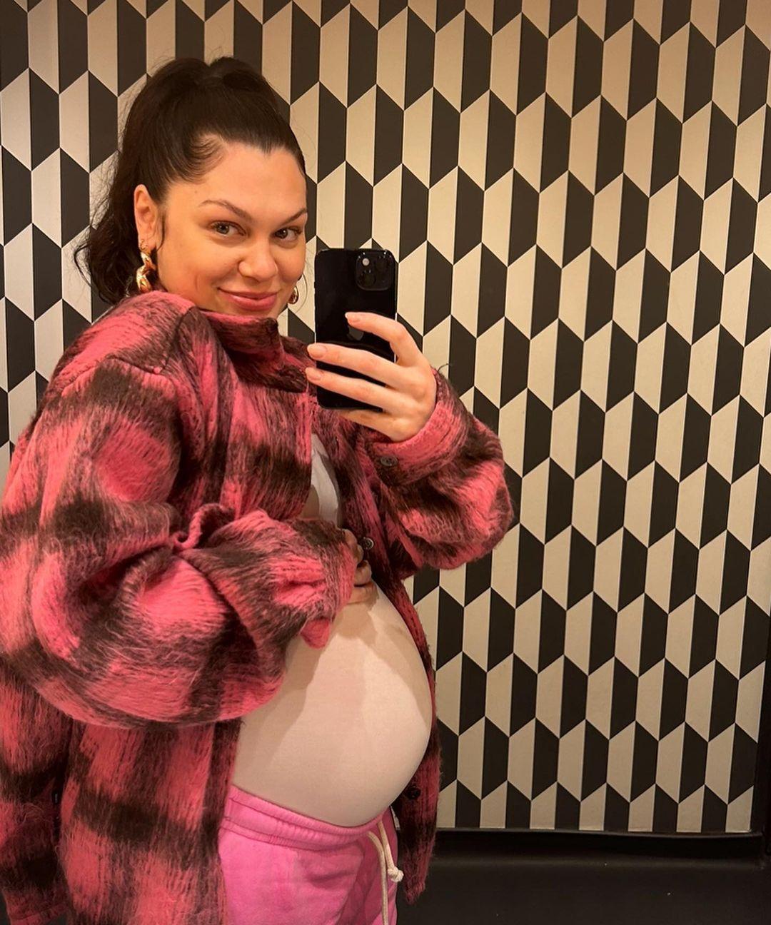 Джесси Джей с улыбкой делает зеркальное селфи, нежно обнимая свой округлившийся животик.