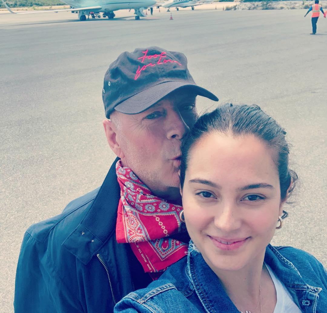 Брюс Уиллис нежно целует Эмму Хеминг Уиллис в щеку.