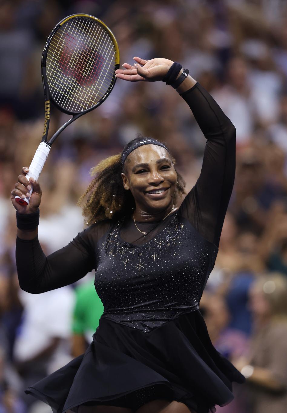 Серена Уильямс ликует после победы на US Open 2022, подняв ракетку над головой.