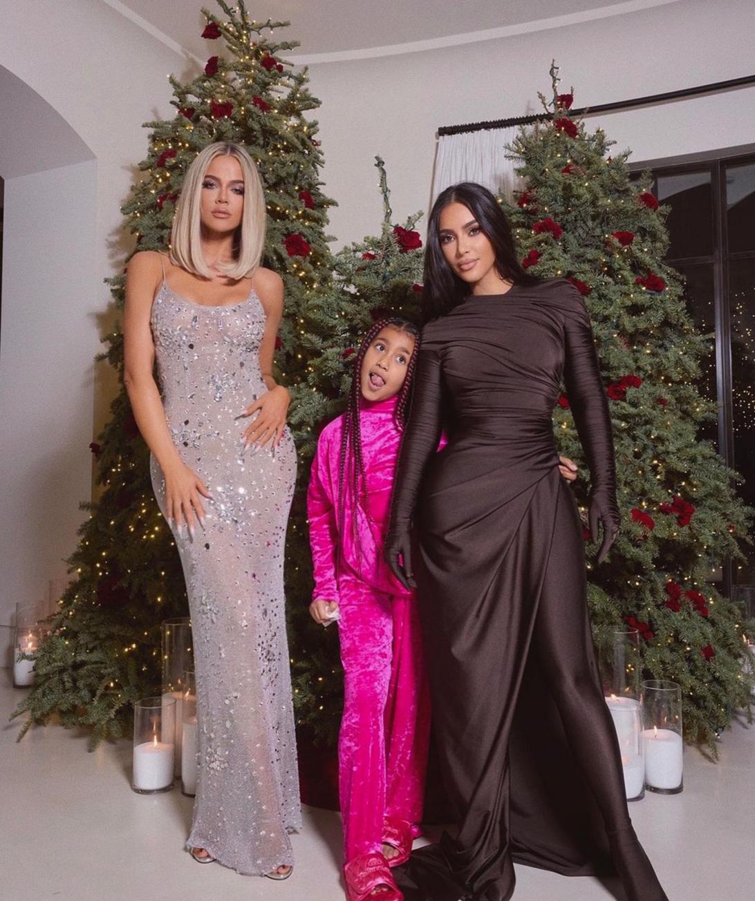 Хлоя Кардашьян, Норт Уэст и Ким Кардашьян позируют на фоне нарядных рождественских елок.